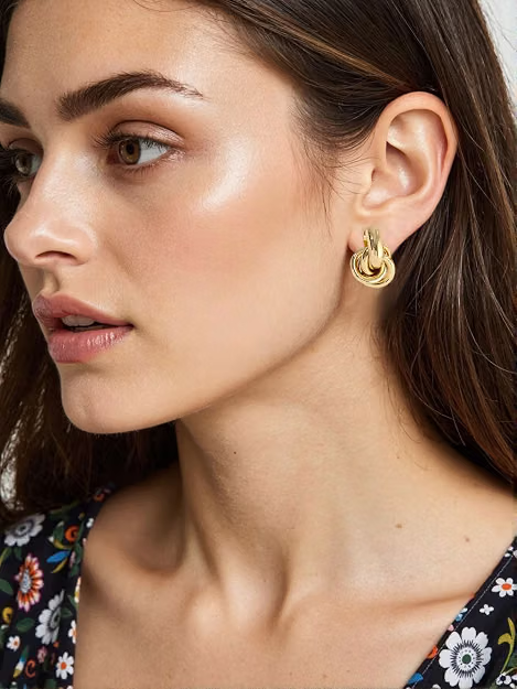 Gold statement hoop earrings that complement the warm neutral workwear palette